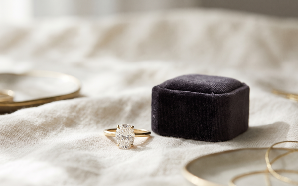 Oval lab-grown diamond engagement ring in yellow gold on ivory linen