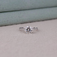 Diamond ring on a light gray surface with a neutral background