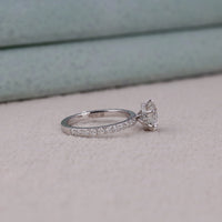 Silver ring with a diamond on a light gray surface