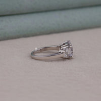 Silver ring with a diamond on a light gray surface