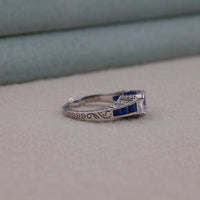 Silver ring with blue gemstones on a gray surface