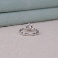 Two silver rings with diamond accents on a light gray surface
