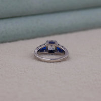 Silver ring with blue gemstone on a beige surface