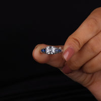 Hand holding a diamond ring with a black background