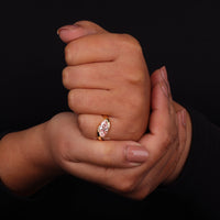 Hand wearing a diamond ring on a black background