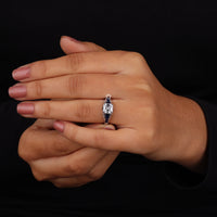 Hand wearing a diamond ring on a black background