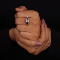 Hand wearing a diamond ring on a black background