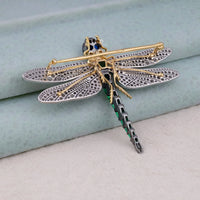 Decorative dragonfly brooch with gold, silver, and green details on a light blue background, Colorful Dragonfly Brooch with Emerald, Ruby, Sapphire & White & Yellow CZ Stones