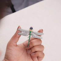 Jewelry store display of a dragonfly-shaped brooch with gemstones, Sparkling Multi-Gemstone Dragonfly Brooch – Emerald, Ruby, Sapphire & CZ Design