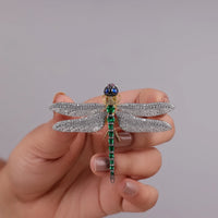 Hand holding a decorative dragonfly brooch with gemstones against a plain background, White & Yellow CZ Gemstone Dragonfly Brooch – Emerald, Ruby & Sapphire Accents