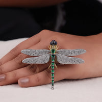 Dragonfly-shaped brooch with gemstones on a hand against a neutral background, Luxury Dragonfly Pin – Multi-Gemstone Brooch with Emerald, Ruby, Sapphire & CZ Accents