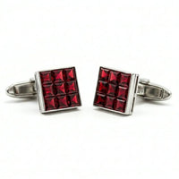 Red square cufflinks with silver border on a white background