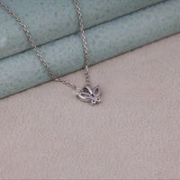 Silver butterfly necklace on a textured surface, Butterfly Shaped Moissanite Pendant Necklace – Sparkling Marquise & Round Stones