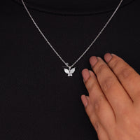 Butterfly necklace on a black background with a hand touching it, Butterfly Design Moissanite Pendant – Marquise & Round Cut Stones in 14K Gold