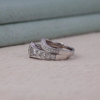 Silver ring with embedded diamonds on a textured surface