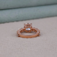 Rose gold ring with gemstone on a light gray surface