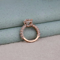 Rose gold ring with diamond accents on a textured surface