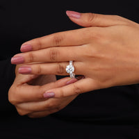 Hand wearing a diamond ring with a black background