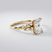 Gold ring with a large diamond and smaller diamonds on a light gray background