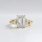 Gold ring with a large diamond and smaller diamonds on the sides against a light gray background
