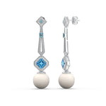 Pair of earrings with blue gemstones and white spherical elements on a white background