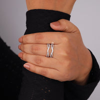 Hand wearing a silver ring with a black background, Moissanite Diamond Guard Band – Round Cut Enhancer Wedding Ring
