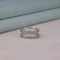 Silver ring with diamond accents on a light pink surface, Round Moissanite Wedding Ring Guard – Diamond Enhancer Band for Solitaire Rings