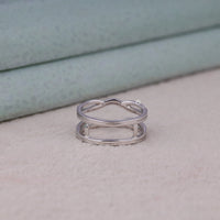 Silver ring with a unique design on a light surface, Moissanite Guard Enhancer Wedding Band – Round Cut Diamond Stacking Ring