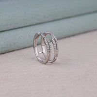 Silver ring with diamond accents on a light gray surface, Round Moissanite Diamond Enhancer Guard Wedding Band