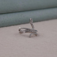 Silver snake-shaped ring with embedded stones on a neutral background