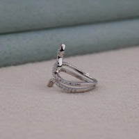 Silver ring with small diamonds on a beige surface