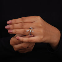Close-up of a hand wearing a silver ring on a black background