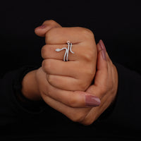 Close-up of a hand wearing a silver ring on a black background