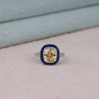 Ring with yellow gemstone and blue accents on a light background, Heirloom Style Sapphire Halo Ring – Antique Old Mine Cut CZ Art Deco Jewelry