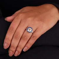Close-up of a hand wearing a diamond ring with a blue gemstone on a black background, Vintage Sapphire Halo Ring – Old Mine Cut CZ Stone Art Deco Inspired Jewelry