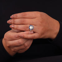 Close-up of a hand wearing a decorative ring on a black background, Antique Art Deco Sapphire Halo Ring – Old Mine Cut CZ Vintage Style Jewelry