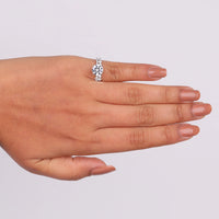 Hand wearing a silver ring on a light gray background, Elegant Moissanite Solitaire Engagement Ring with Matching Eternity Band for Brides