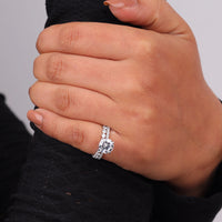 Close-up of a hand wearing a diamond ring on a neutral background, Moissanite Bridal Ring Set, Round Solitaire Engagement Ring with Full Eternity Band