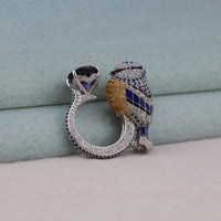 Ornate silver ring with gemstones on a light blue background