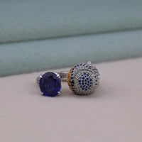 Two silver rings with blue gemstones on a light gray surface.