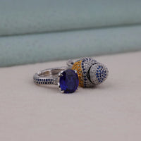 Two rings with gemstones on a neutral background