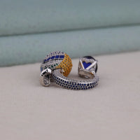 Pair of silver earrings with colorful gemstones on a light gray surface.