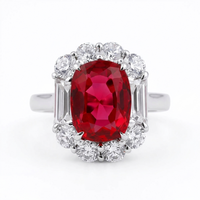 Ring with a red gemstone and diamond accents on a white background
