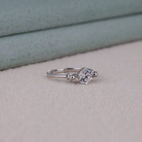 Silver ring with a diamond on a light gray surface