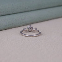 Silver ring with a diamond on a light gray surface
