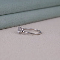 Silver ring with a diamond on a light gray surface