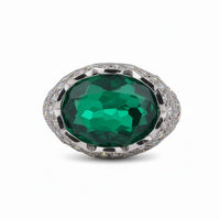 Ring with a large green gemstone and silver accents on a white background