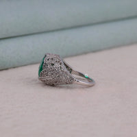 Silver ring with emerald stone on a light background, Green Oval CZ Stone Intertwined Infinity Design Art Deco Vintage Cocktail Ring, Vintage Inspired Green Oval CZ Party Ring