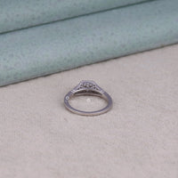 Silver ring with intricate design on a textured surface, timeless engagement ring, eco-friendly engagement ring