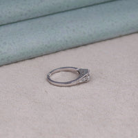 Silver ring with a diamond on a beige surface, ethical bridal ring
gold moissanite ring